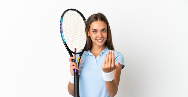 Mujer joven sobre fondo blanco aislado jugando al tenis y haciendo el gesto que viene