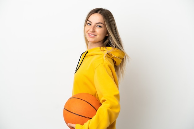 Mujer joven sobre fondo blanco aislado jugando baloncesto