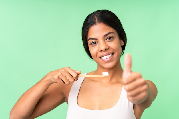 Foto mujer joven sobre fondo croma key aislado con un cepillo de dientes