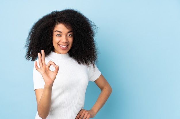 Mujer joven sobre mostrar signo bien con los dedos