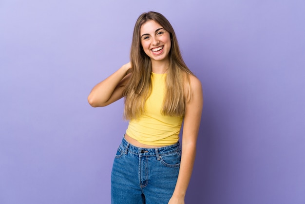 Mujer joven sobre pared púrpura aislada riendo