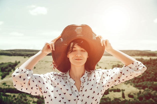 Mujer joven con sombrero disfrutando del paisaje de las montañas Viajes Estilo de vida feliz emociones concepto aventura vacaciones activas al aire libre en el Cáucaso Sonrisa turística niña caminando