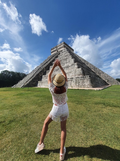 Mujer joven con sombrero en el fondo de Chichén Itzá