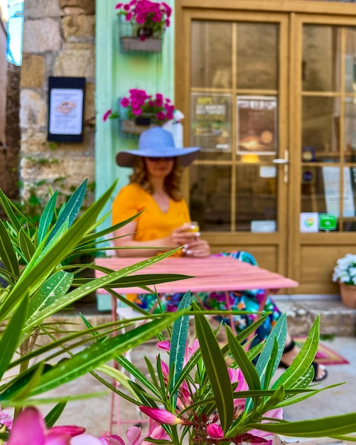 Una mujer joven con un sombrero en el fondo flores en primer plano