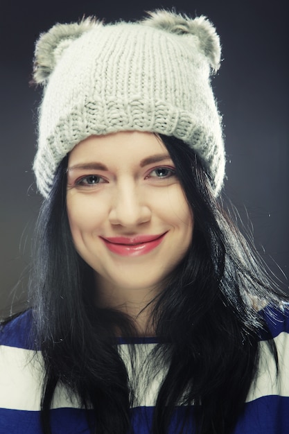 Mujer joven con sombrero gracioso de invierno