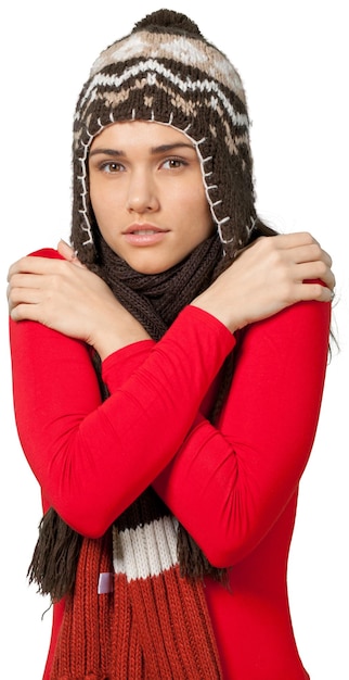 Mujer joven con un sombrero de invierno y una bufanda de invierno frotándose los hombros