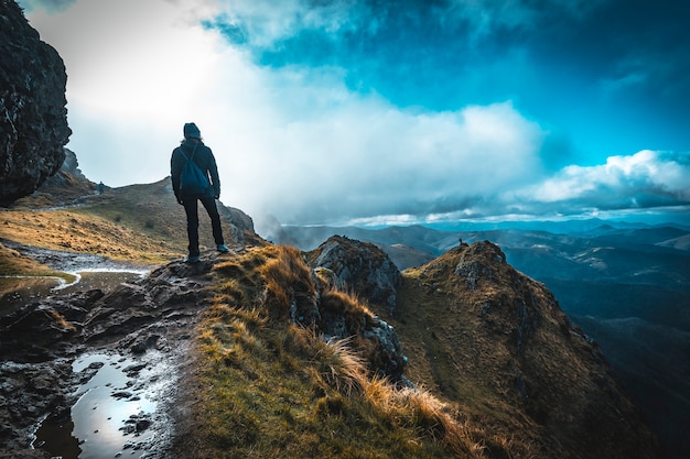 Una mujer joven con sombrero de invierno mirando a la montaña de aiako harriak, oiartzun. país vasco