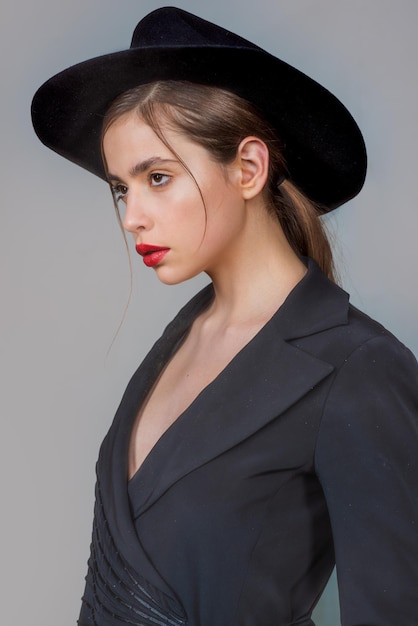 Mujer joven con sombrero de moda. Retrato de niña hermosa. Mujer de moda y elegante en sombrero de moda, maquillaje de labios rojos. Look de moda, belleza y estilo. Fondo gris.