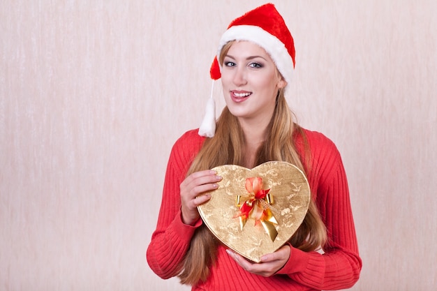 Mujer joven con sombrero de Santa Claus con caja de regalo