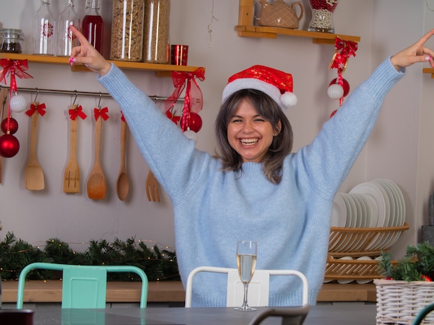 Una mujer joven con un sombrero de Santa Claus es feliz