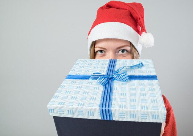 Mujer joven con sombrero de Santa con regalo