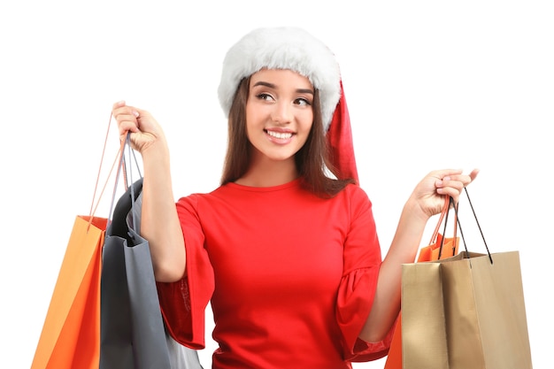 Mujer joven con sombrero de Santa sosteniendo bolsas de colores sobre fondo blanco. Concepto del día de San Esteban