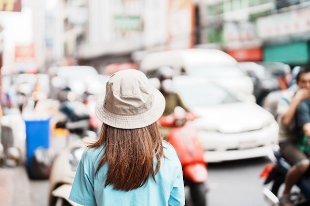 Mujer joven con sombrero viajando en Bangkok Viajero asiático visitando la calle Yaowarat o el barrio chino de Bangkok, punto de referencia y popular para las atracciones turísticas en Tailandia Sudeste asiático Concepto de viaje