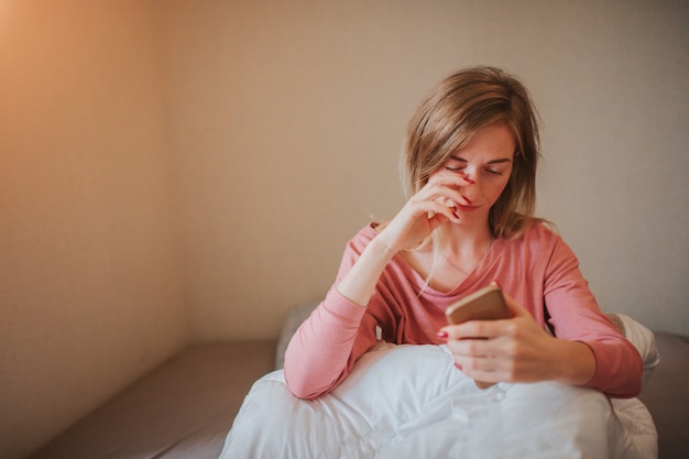 Mujer joven soñolienta que despierta con alarma. Ella se durmió para trabajar