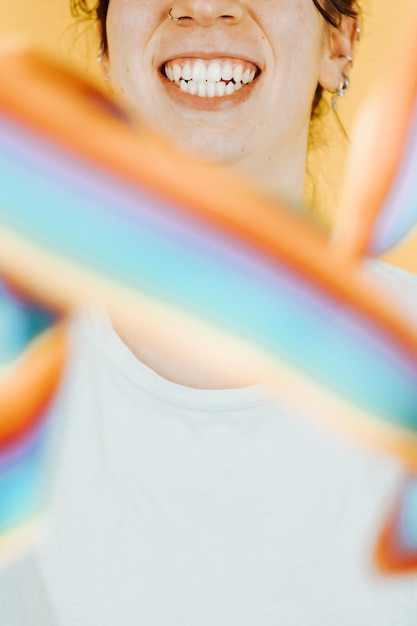 Mujer joven sonriendo alegremente a la cámara mientras sostiene una bandera LGBTIQ saludando a la cámara Orgullo de mujer lesbiana y luchando por sus derechos El amor es un concepto de amor