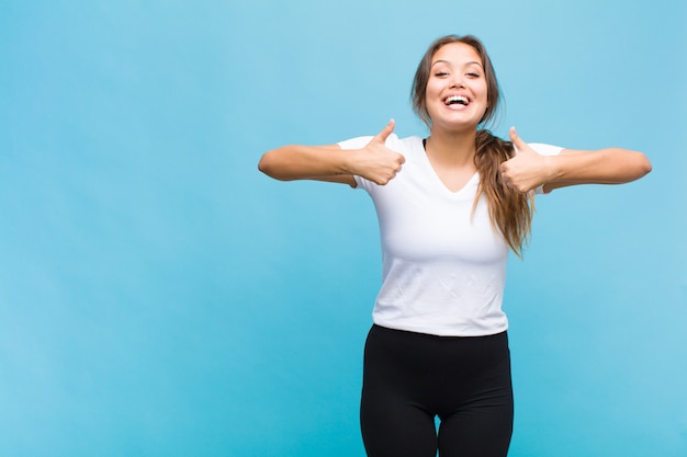 Mujer joven sonriendo ampliamente mirando feliz, positivo