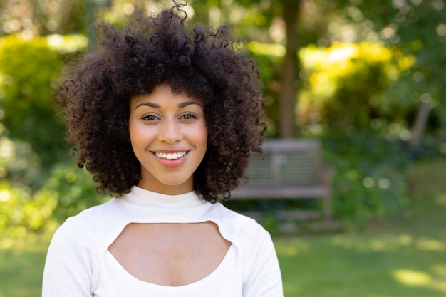 Mujer joven sonriendo a la cámara en el jardín