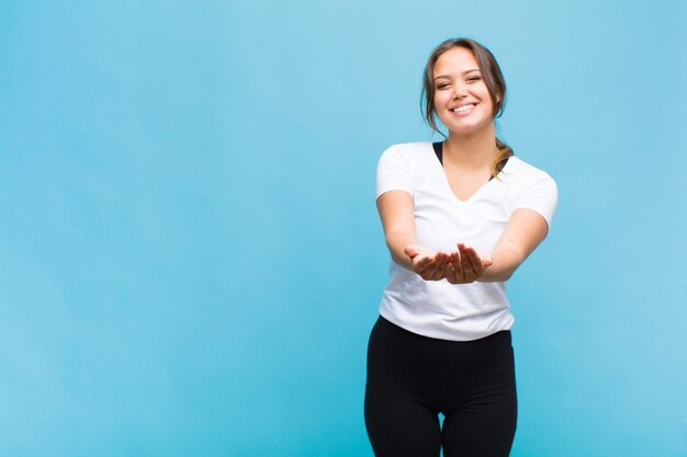 Mujer joven sonriendo felizmente con amigable