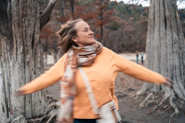 Foto mujer joven sonriendo mientras está de pie en tierra