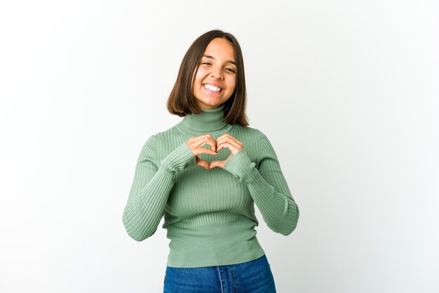 Foto mujer joven sonriendo y mostrando una forma de corazón con las manos