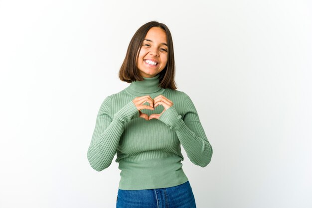 Mujer joven sonriendo y mostrando una forma de corazón con las manos