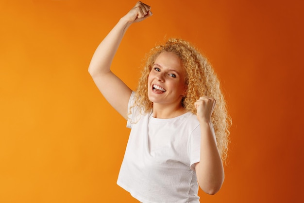 Mujer joven sonriente alegre feliz celebrando el éxito