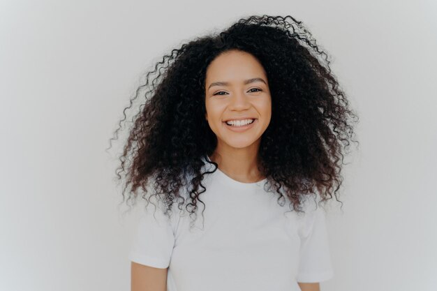 Mujer joven sonriente con cara feliz dientes perfectos vestida casualmente aislada sobre fondo blanco abrazando una nueva vida