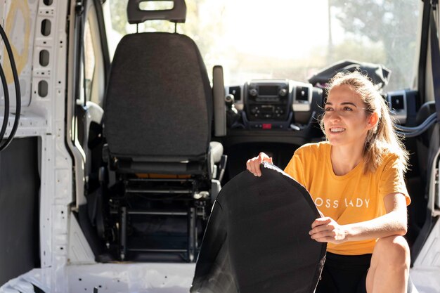 Mujer joven sonriente feliz sosteniendo aislamiento de goma para una conversión construida en autocaravana con espacio de copia