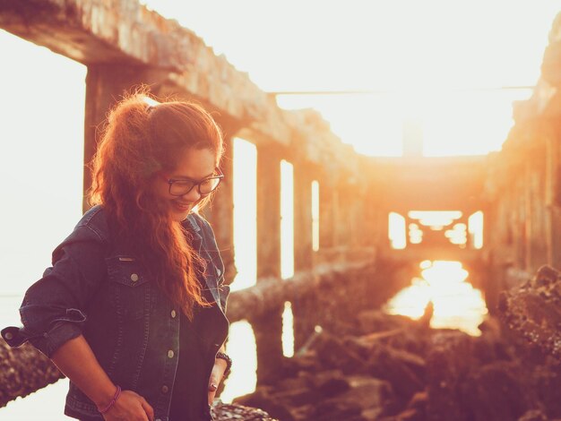 Foto mujer joven sonriente de pie contra el cielo