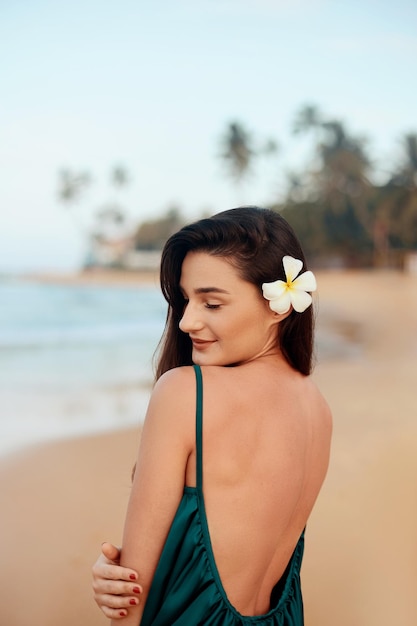 mujer joven, sonriente, retrato, de, hermoso, niña, en, traje de baño, con, océano, en, plano de fondo