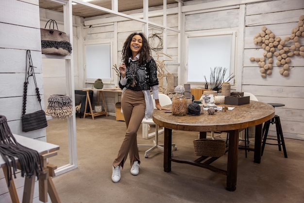 Foto mujer joven sonriente con ropa de estilo boho en el estudio de arte