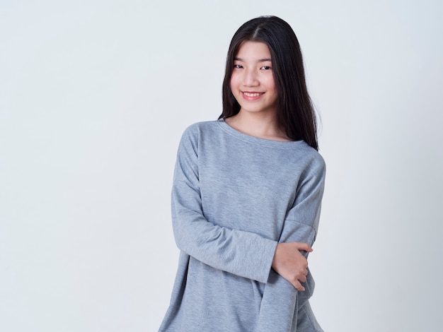 Mujer joven sonriente sobre la pared blanca