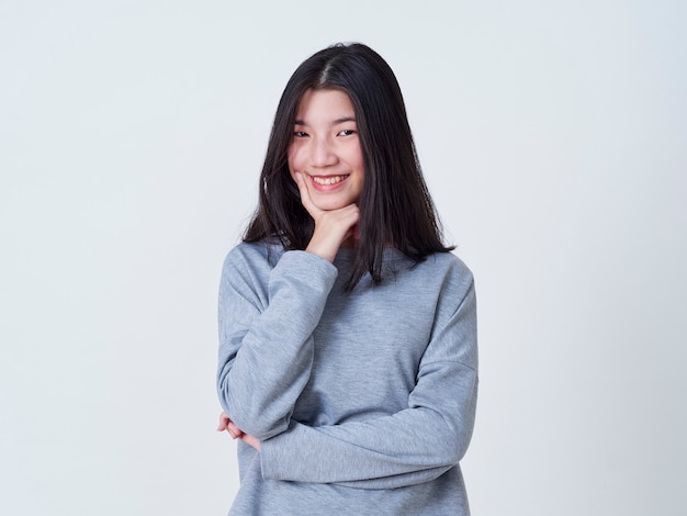 Mujer joven sonriente sobre la pared blanca