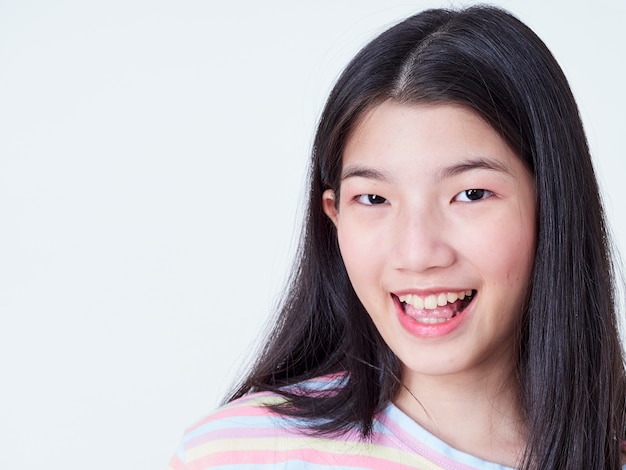 Mujer joven sonriente sobre la pared blanca