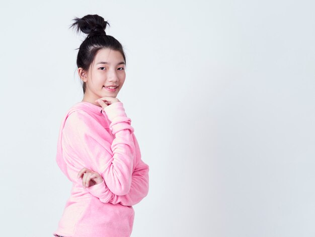 Mujer joven sonriente sobre la pared blanca