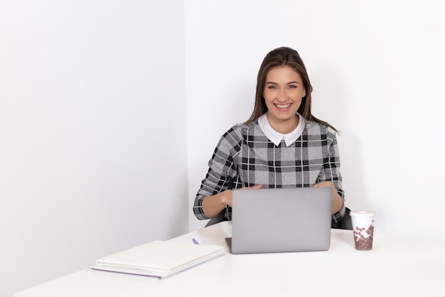 mujer joven, sonriente, trabajo encendido, computador portatil, en, oficina