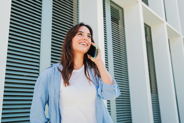 Foto mujer joven sonriente usando llamando usando un teléfono móvil hablando sonriente ordenando entrega feliz