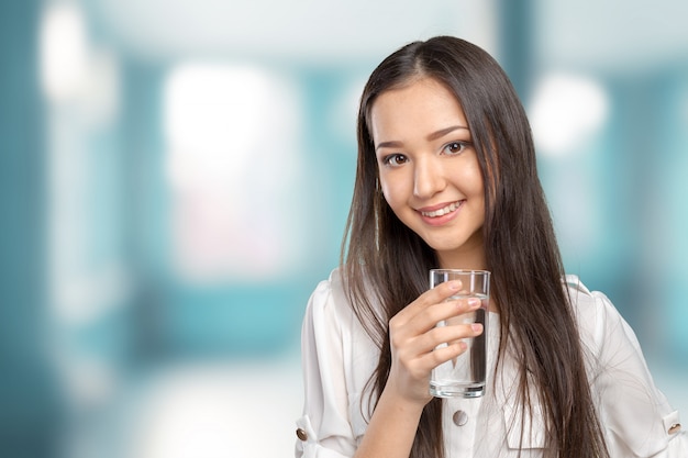 Mujer joven sonriente con vaso de agua