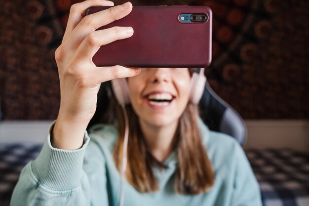 Foto mujer joven sonriente en videoconferencia por teléfono móvil