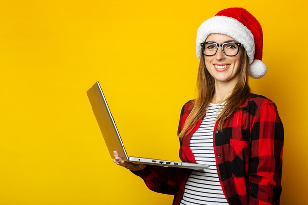 Mujer joven con una sonrisa en un gorro de Papá Noel