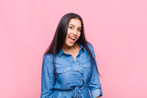 Mujer joven con una sonrisa grande, amigable y despreocupada, con un aspecto positivo, relajado y feliz, escalofriante