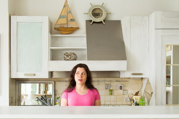 Foto mujer joven sorprendida en la cocina de casa