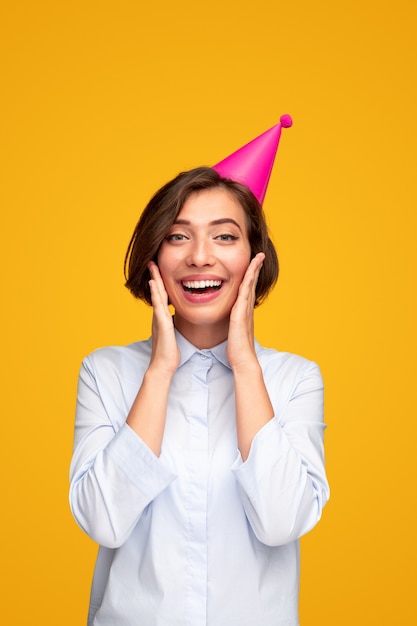 Mujer joven sorprendida en gorro de fiesta