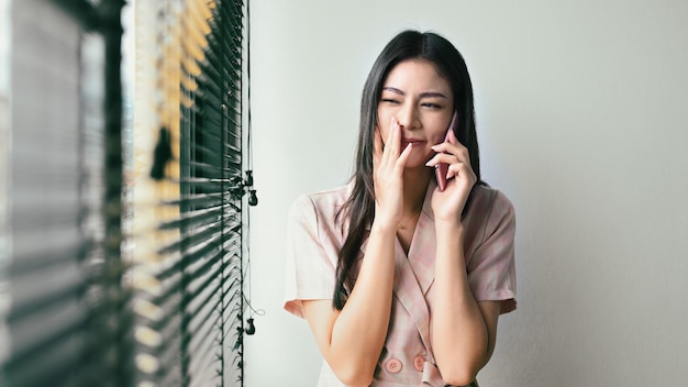 Mujer joven sorprendida teniendo una conversación agradable recibiendo buenas negociaciones de noticias con un socio comercial en el teléfono móvil