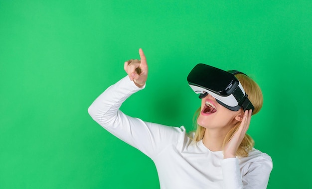 Mujer joven sorprendida tocando el aire durante la experiencia de realidad virtual Mujer viendo la visión de realidad virtual Una persona con gafas virtuales vuela en el espacio de la habitación Realidad de simulación y nueva tecnología de juegos