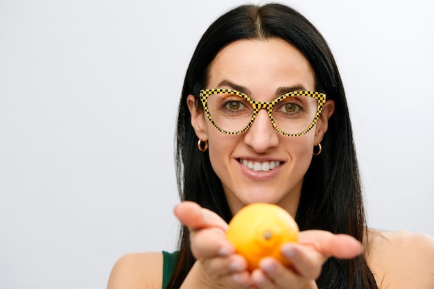 Mujer joven sostenga limón crudo fresco amarillo cítricos hembra sonrisa feliz aislado sobre fondo blanco concepto de alimentos orgánicos naturales