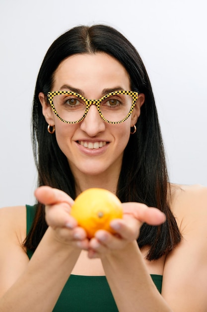Mujer joven sostenga limón crudo fresco amarillo cítricos hembra sonrisa feliz aislado sobre fondo blanco concepto de alimentos orgánicos naturales