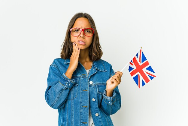 Mujer joven sosteniendo una bandera inglesa con un fuerte dolor de dientes, dolor molar