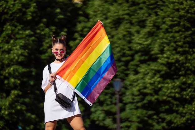 Mujer joven sosteniendo una bandera del orgullo LGBT en sus manos