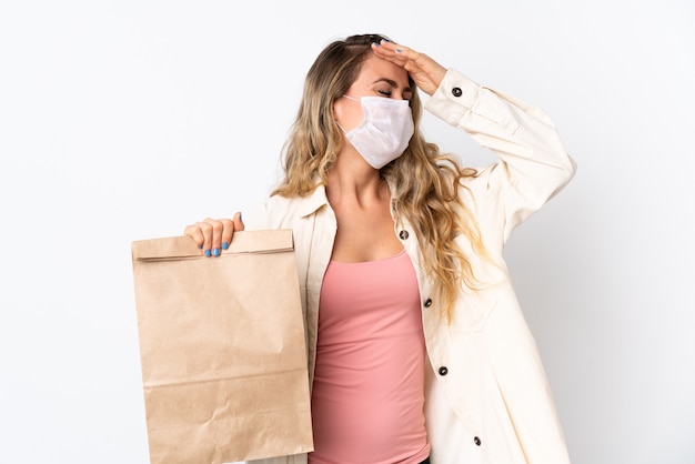 Mujer joven sosteniendo una bolsa de compras aislada en blanco se ha dado cuenta de algo y tiene la intención de la solución